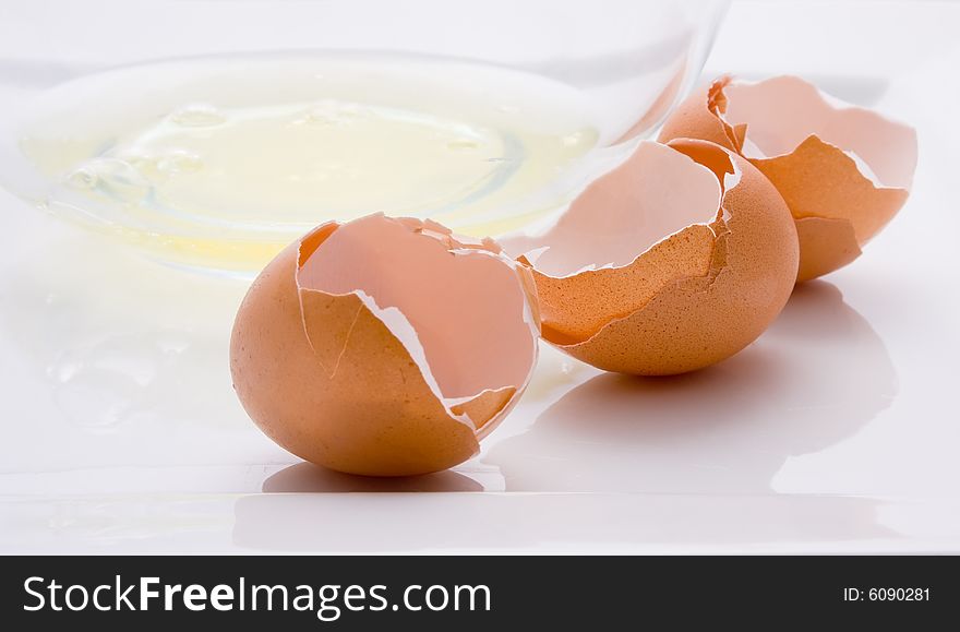 Three broken eggs and a bowl with egg white. Three broken eggs and a bowl with egg white