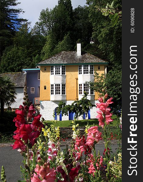 A cottage set in a rural area with flowers growing in front. A cottage set in a rural area with flowers growing in front