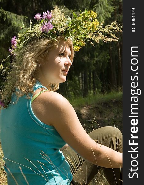 Young beautiful blonde in a forest with flowers diadem. Young beautiful blonde in a forest with flowers diadem