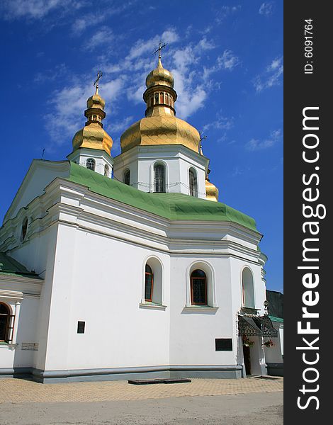 Beautiful church in good weather on a background of the blue sky with white clouds