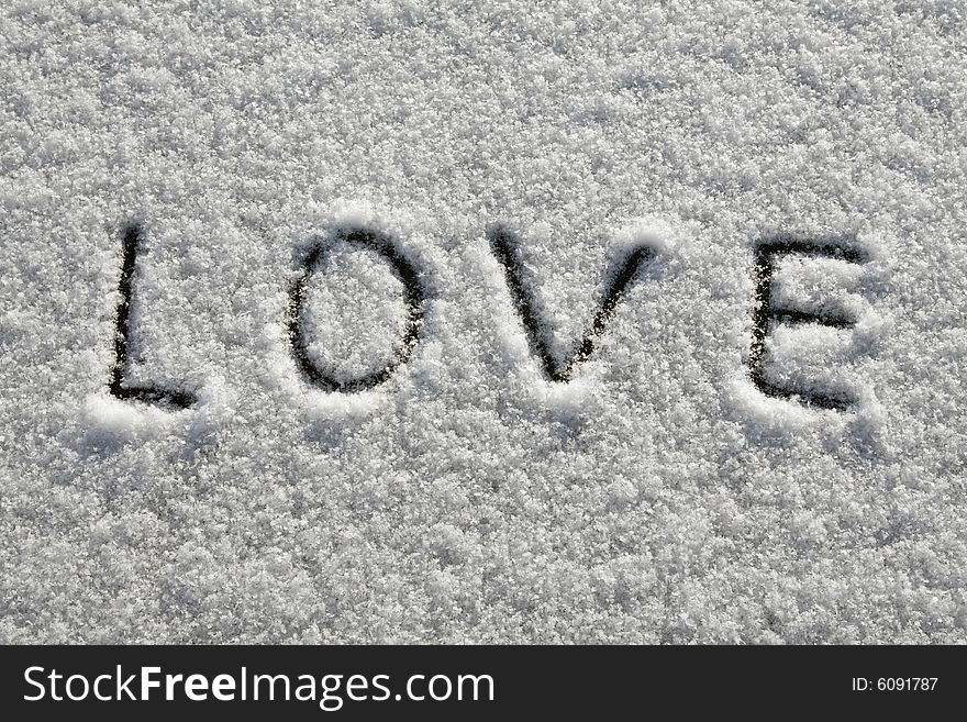 A word 'love' written on fresh snow. A word 'love' written on fresh snow