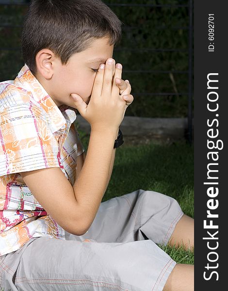Young Boy Praying Outdoors