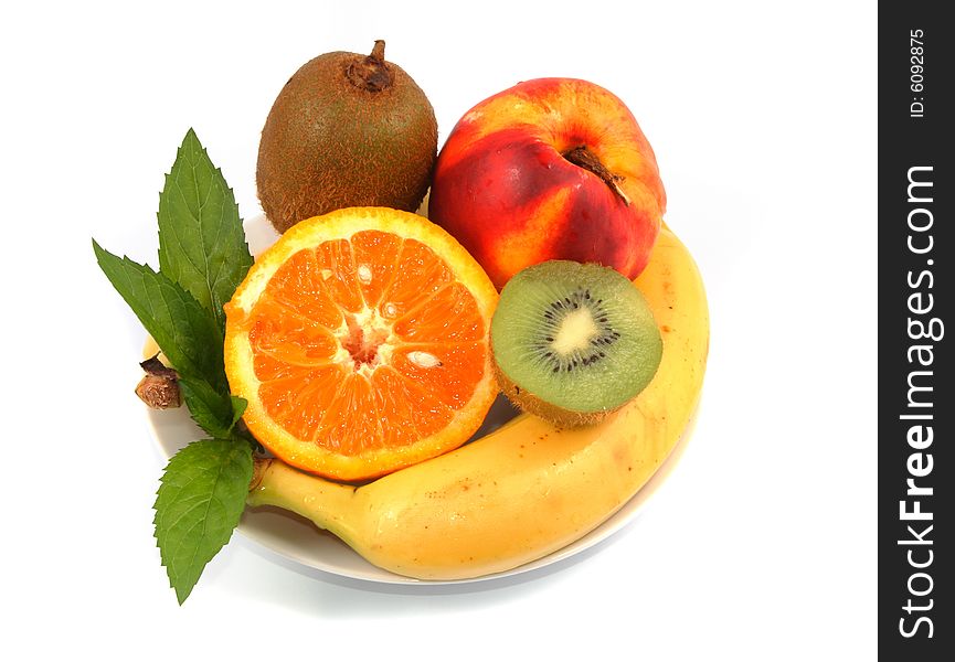 Orange, peach, banana and kiwi in a white plate on light background. Orange, peach, banana and kiwi in a white plate on light background.