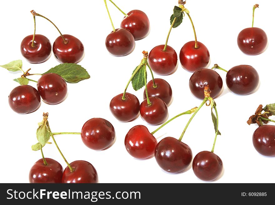 Ripe berries of a cherry of red color and their shadow on light background.