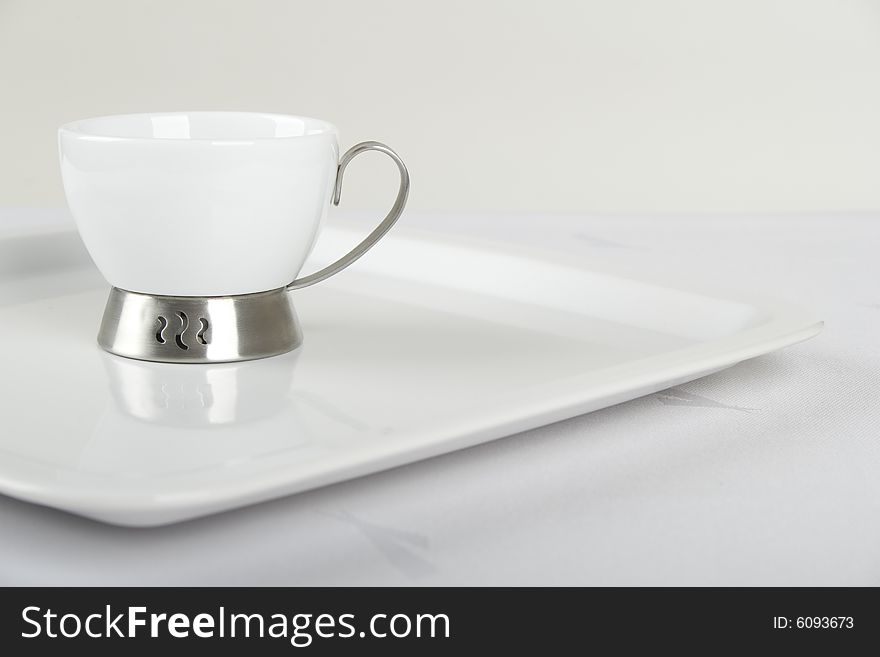 White porcelain cup on white plate