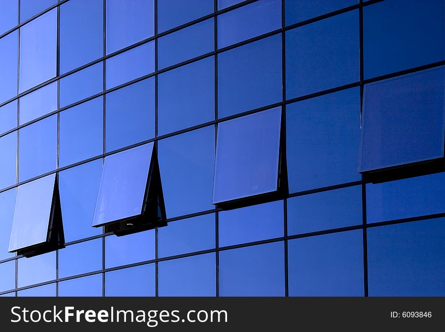 Open windows on blue glass wall of a modern building. Open windows on blue glass wall of a modern building