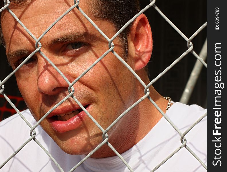 Headshot of a male behind a fence. Headshot of a male behind a fence.