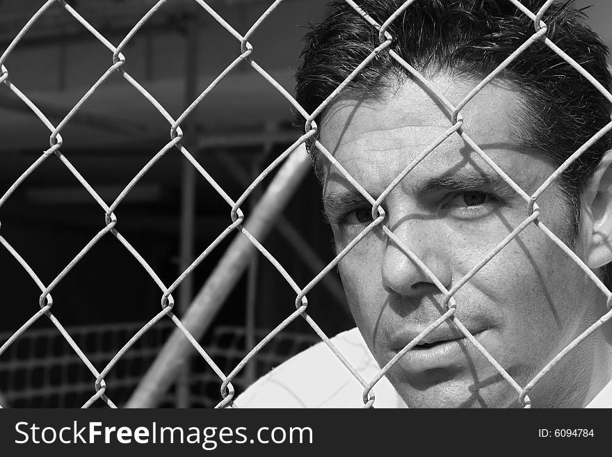 Headshot of a male behind a fence. Headshot of a male behind a fence.