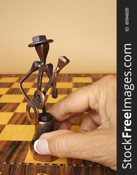 Senior hand holding an iron figure of chess
