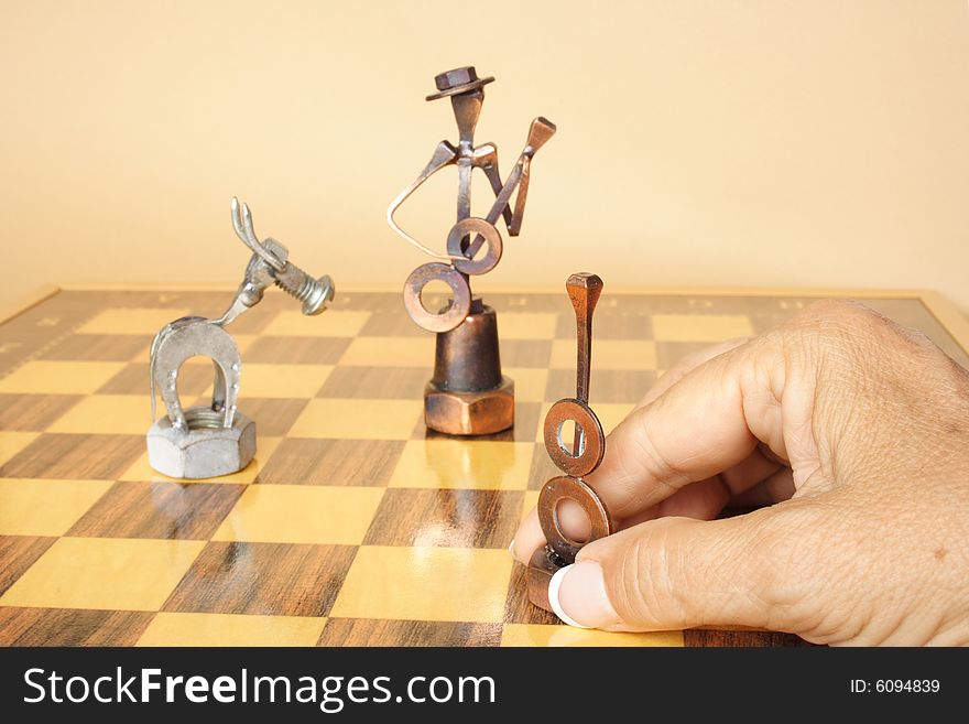 Hand holding figure on a Spanish chess board. Hand holding figure on a Spanish chess board
