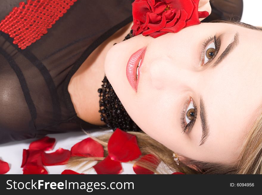Young blond girl face  in rose s petals