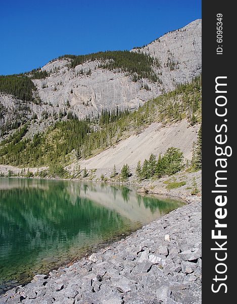 Alpine lake on mountains indefatigable, kananaskis country, alberta, canada