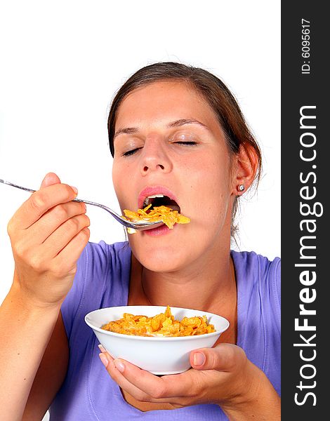 A young woman enjoys her crunchy cornflakes. Isolated over white. A young woman enjoys her crunchy cornflakes. Isolated over white.