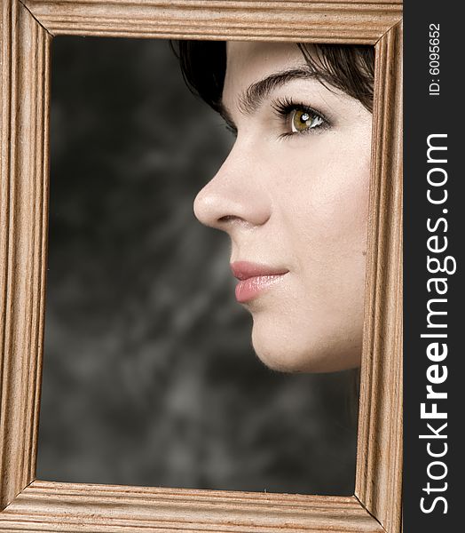 Face of beautiful girl, in a wooden frame