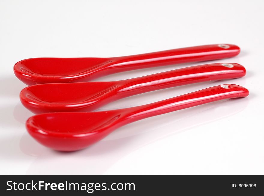 A red spoon, isolated on white in a studio. A red spoon, isolated on white in a studio.