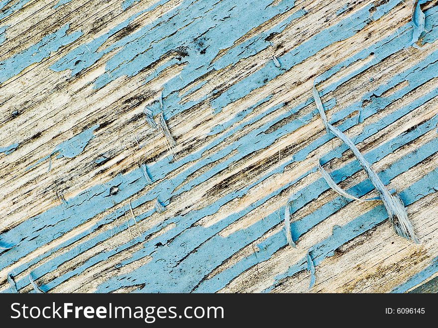 A backgound shot showing the detail of blue paint peeling off an old door