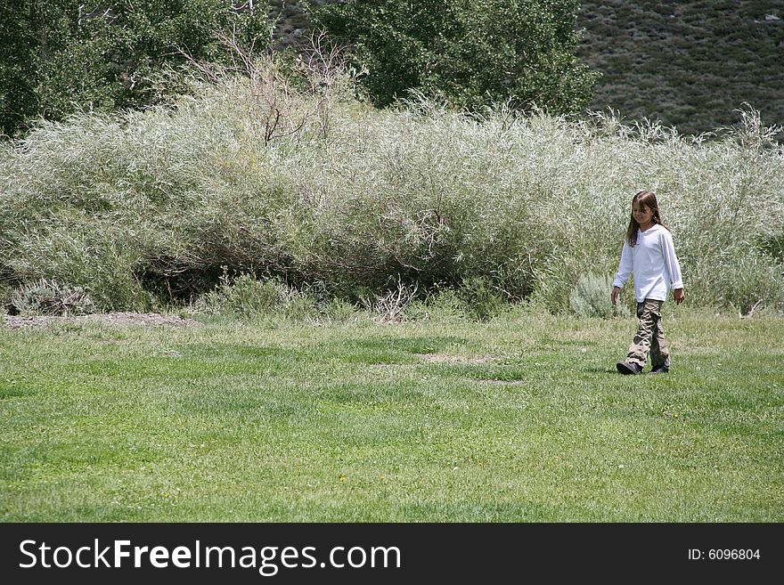 Young child walking across a nature background