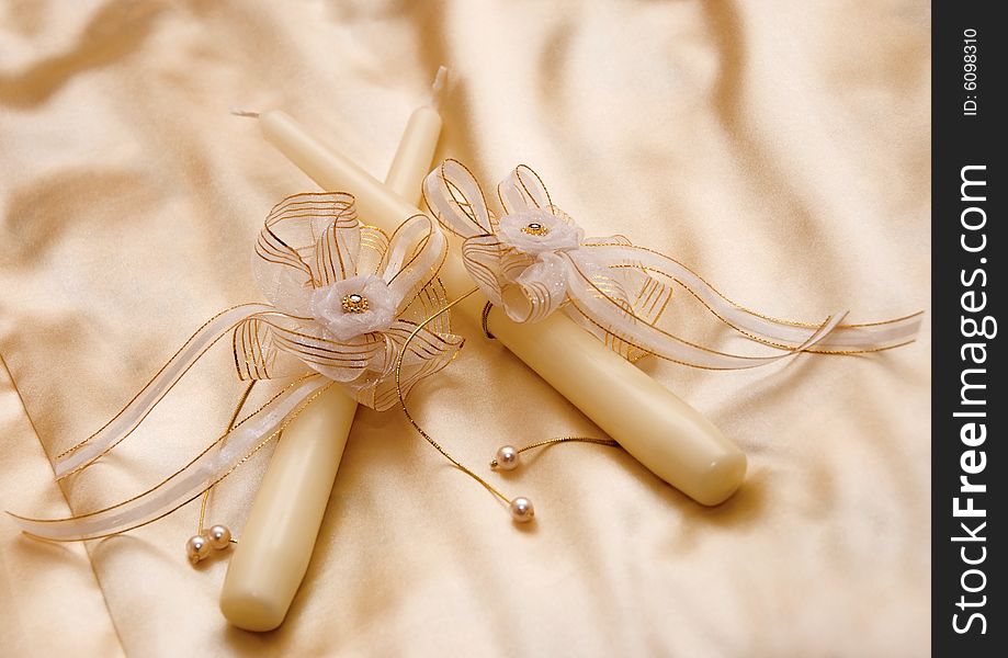 Two wedding candles on the bed