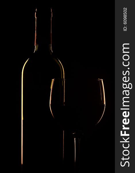 Bottle of wine and glass set against a black backdrop. Bottle of wine and glass set against a black backdrop