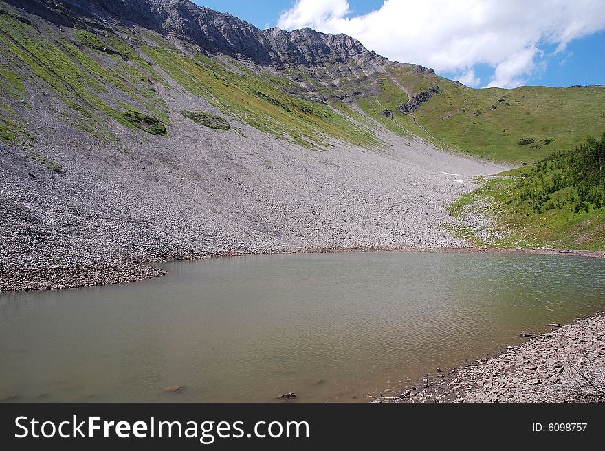 Alpine lake on mountains indefatigable, kananaskis country, alberta, canada
