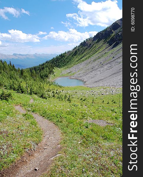 Alpine lake and meadows on mountains indefatigable, kananaskis country, alberta, canada