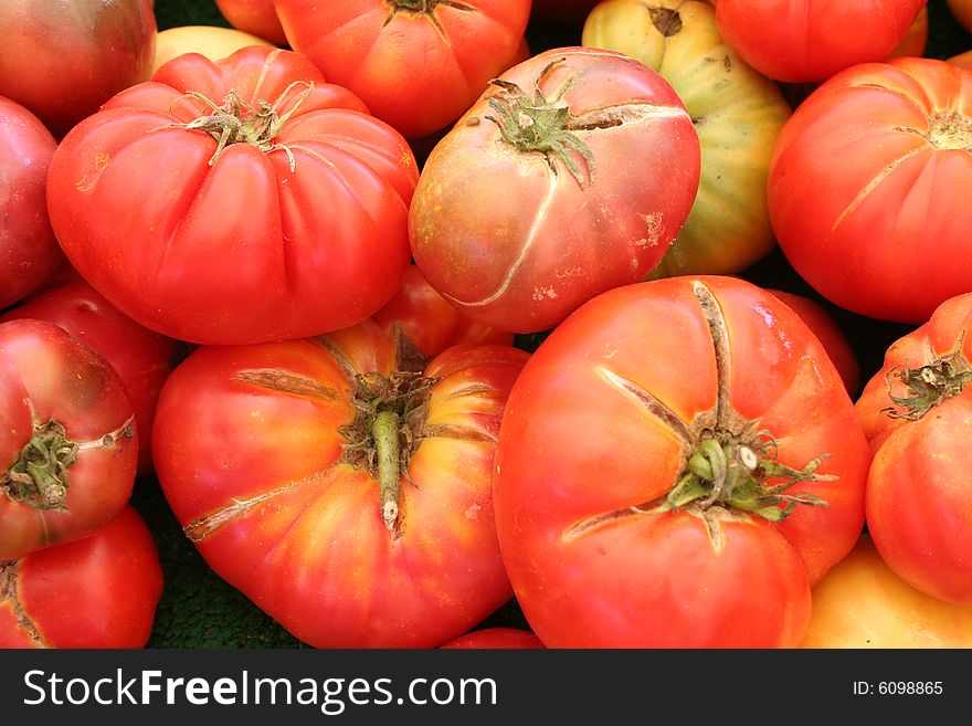 Large colorful tomatoes at a produce market. Large colorful tomatoes at a produce market.