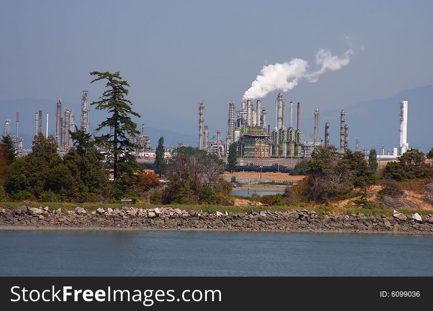 Oil refinery across the bay and behind an area with trees and bushes. Oil refinery across the bay and behind an area with trees and bushes.