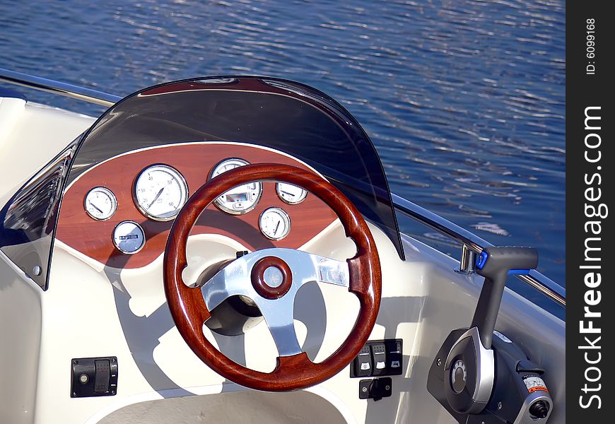 The motor boat wheel and control panel close up. The motor boat wheel and control panel close up.