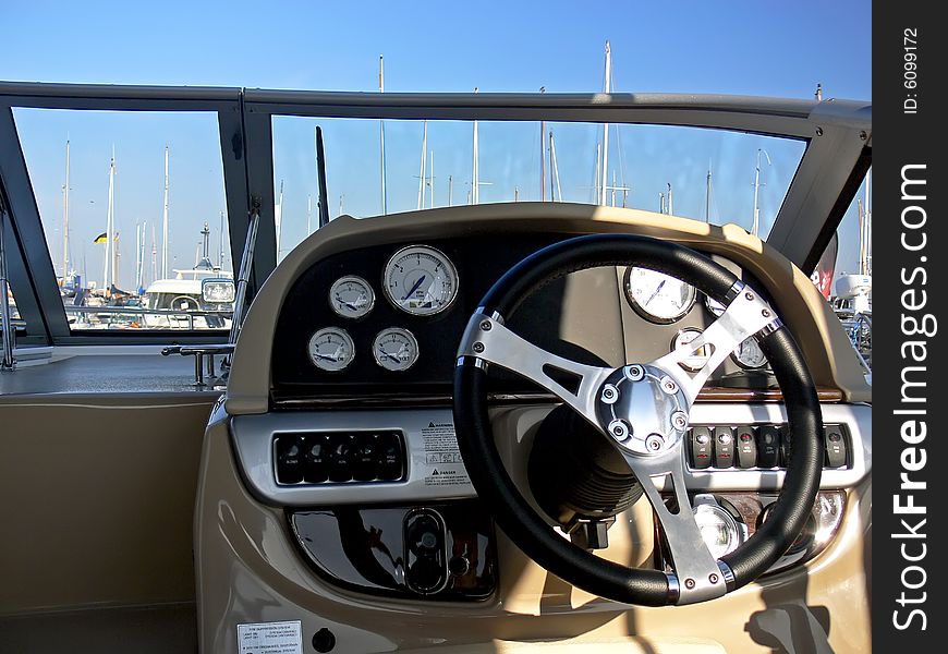 The motor boat wheel and control panel close up. The motor boat wheel and control panel close up.