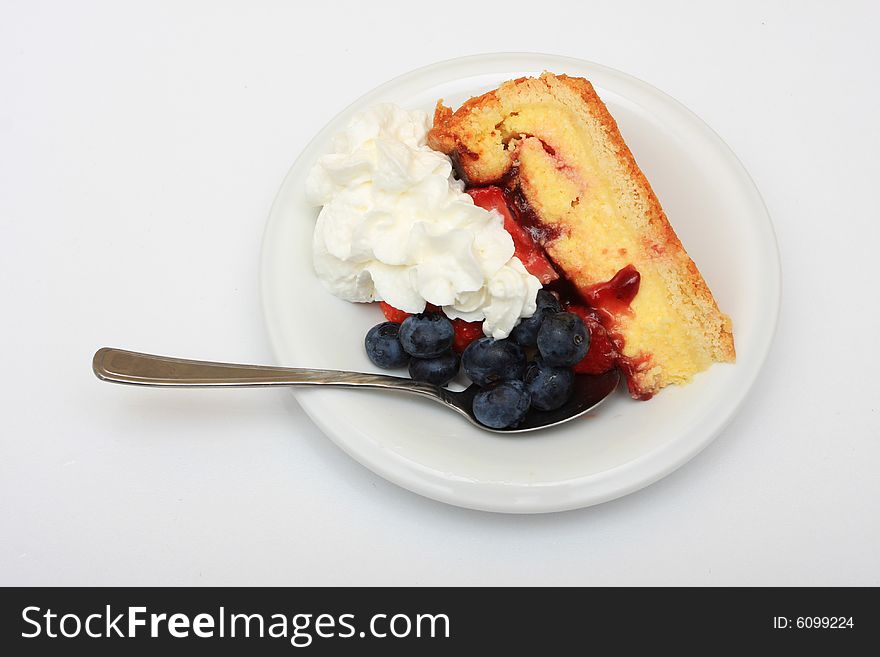 Slice of strawberry cake with whipped cream and blueberries isolated on white. Slice of strawberry cake with whipped cream and blueberries isolated on white