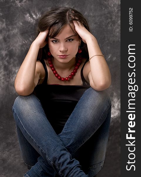 A beautiful young girl sits crossing feet. A beautiful young girl sits crossing feet