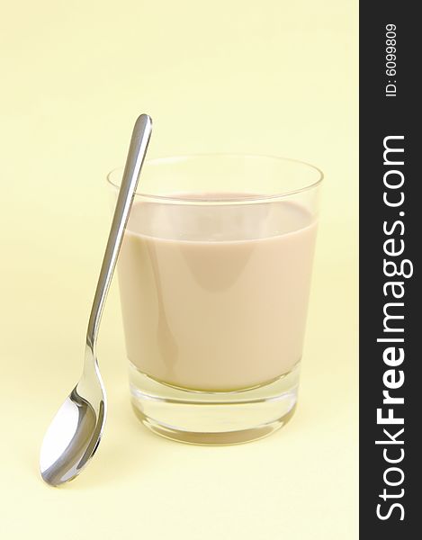 A glass of chocolate milk isolated against a yellow background