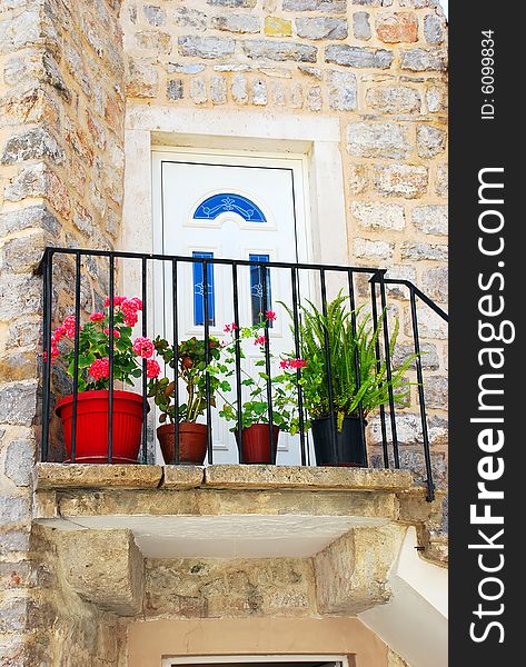Entrance door of old stone house with flowerpots in Budva. Entrance door of old stone house with flowerpots in Budva