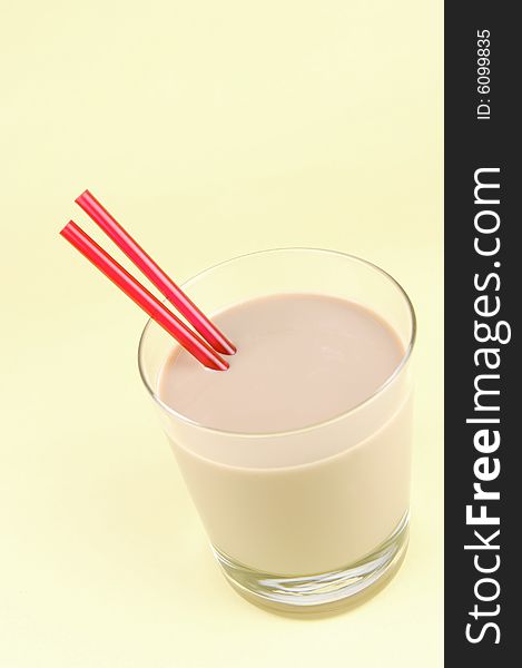 A glass of chocolate milk isolated against a yellow background