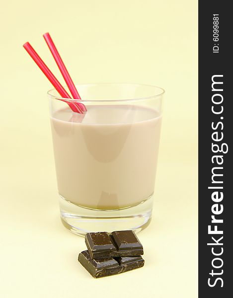 A glass of chocolate milk isolated against a yellow background