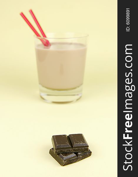 A glass of chocolate milk isolated against a yellow background