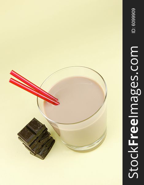 A glass of chocolate milk isolated against a yellow background