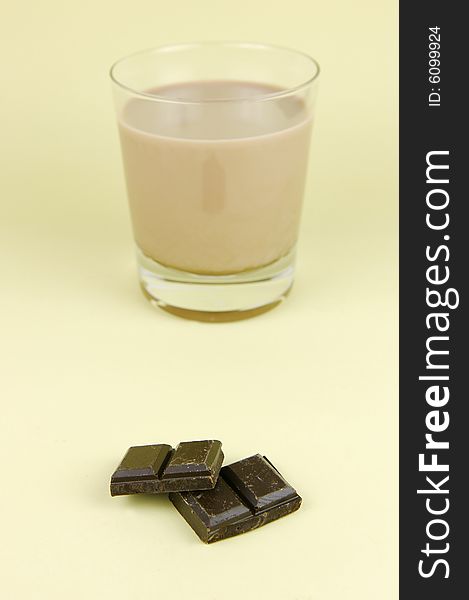 A glass of chocolate milk isolated against a yellow background