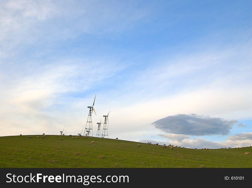 Modern windmills in California, sheep grazign on the hillside