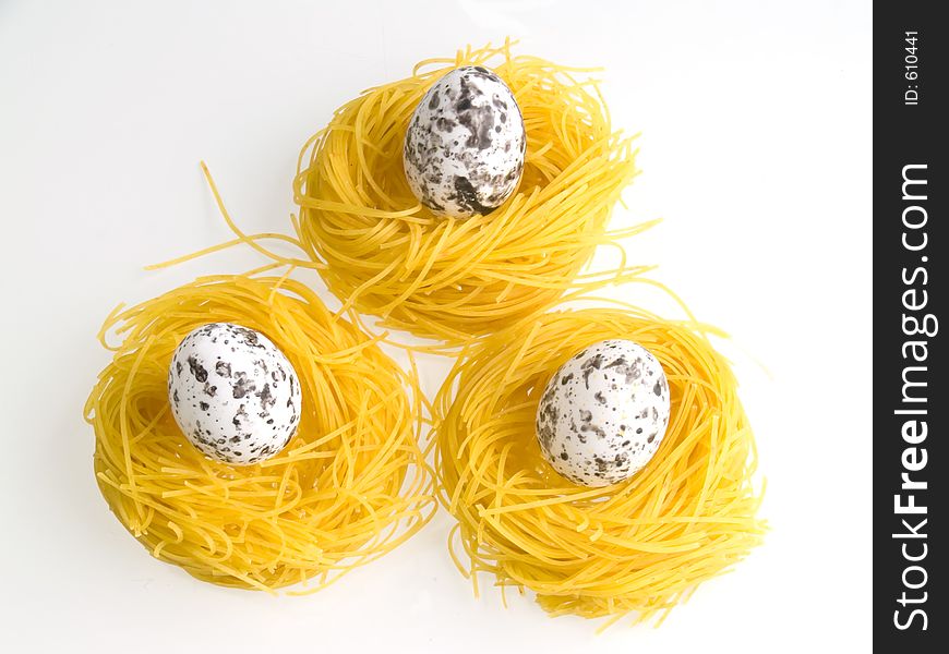 Three eggs on pasta nests, white background