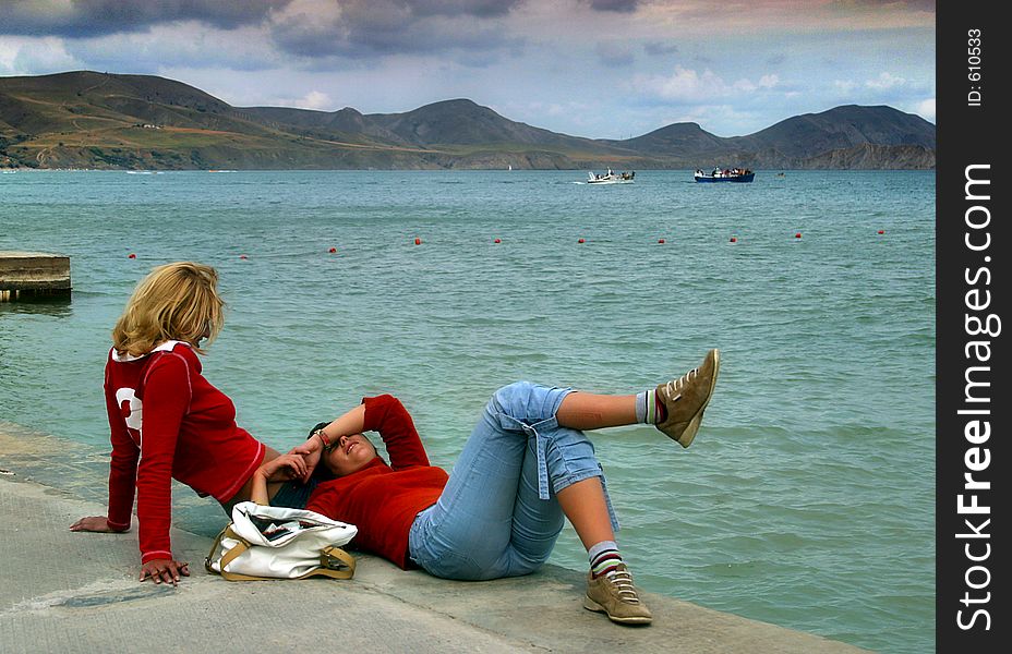 Girlfriends on edge of a pier. Girlfriends on edge of a pier