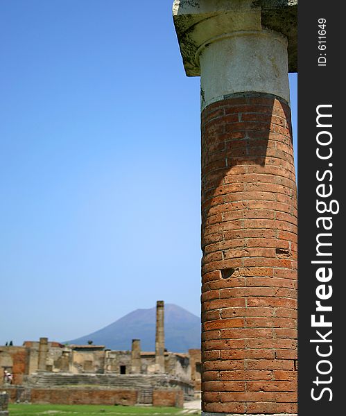 Focused column in foreground with ruins and volcano in background. Focused column in foreground with ruins and volcano in background