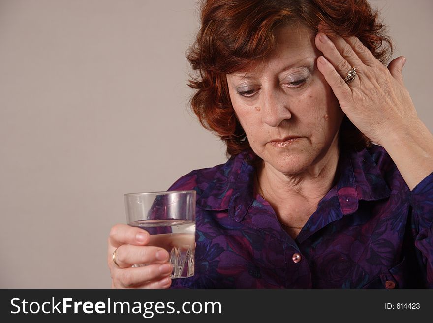 Senior woman. Headache and glass of water in a hand. Senior woman. Headache and glass of water in a hand.