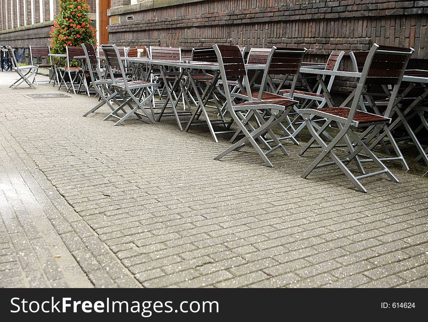 Tables and chairs on a cobbled street in a European city. Tables and chairs on a cobbled street in a European city