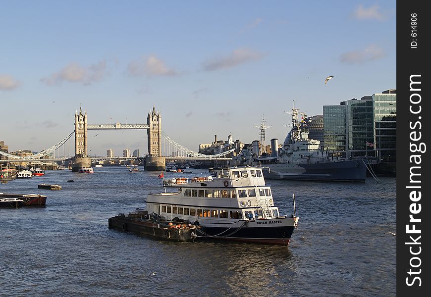 A boat crossing thames river in London and The Tower bridge in the background