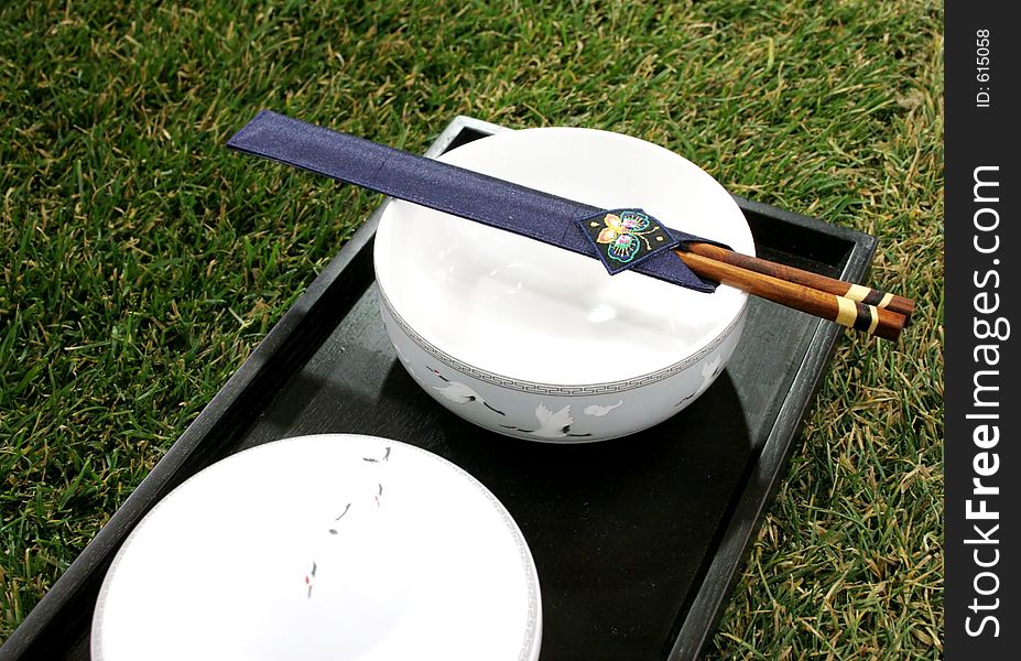 Chopsticks and bowl sitting on the grass. Chopsticks and bowl sitting on the grass