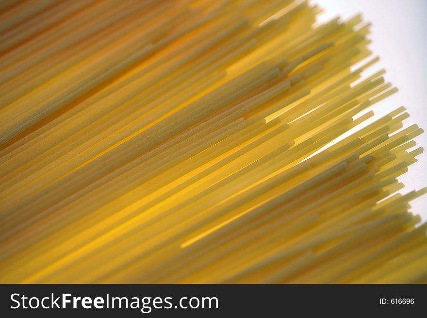 Strands and tips of spaghetti lit from blow form a banded surface. Strands and tips of spaghetti lit from blow form a banded surface