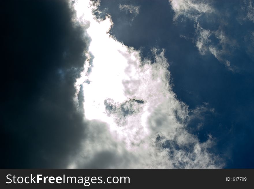 Contrasting sky color/weather. Dark stormy clouds and deep blue sky separated by white clouds.