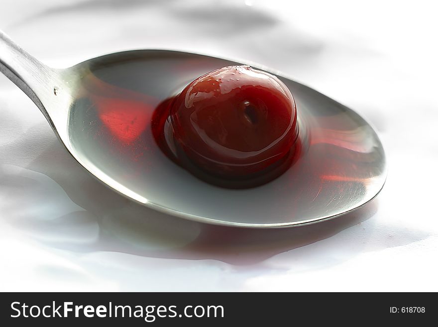 Berry of a cherry in a spoon with juice. Berry of a cherry in a spoon with juice