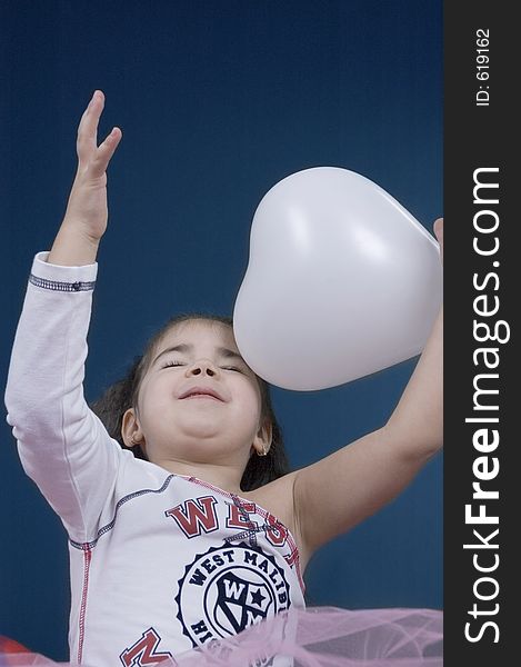 Pretty little girl playing with a balloon looking happy